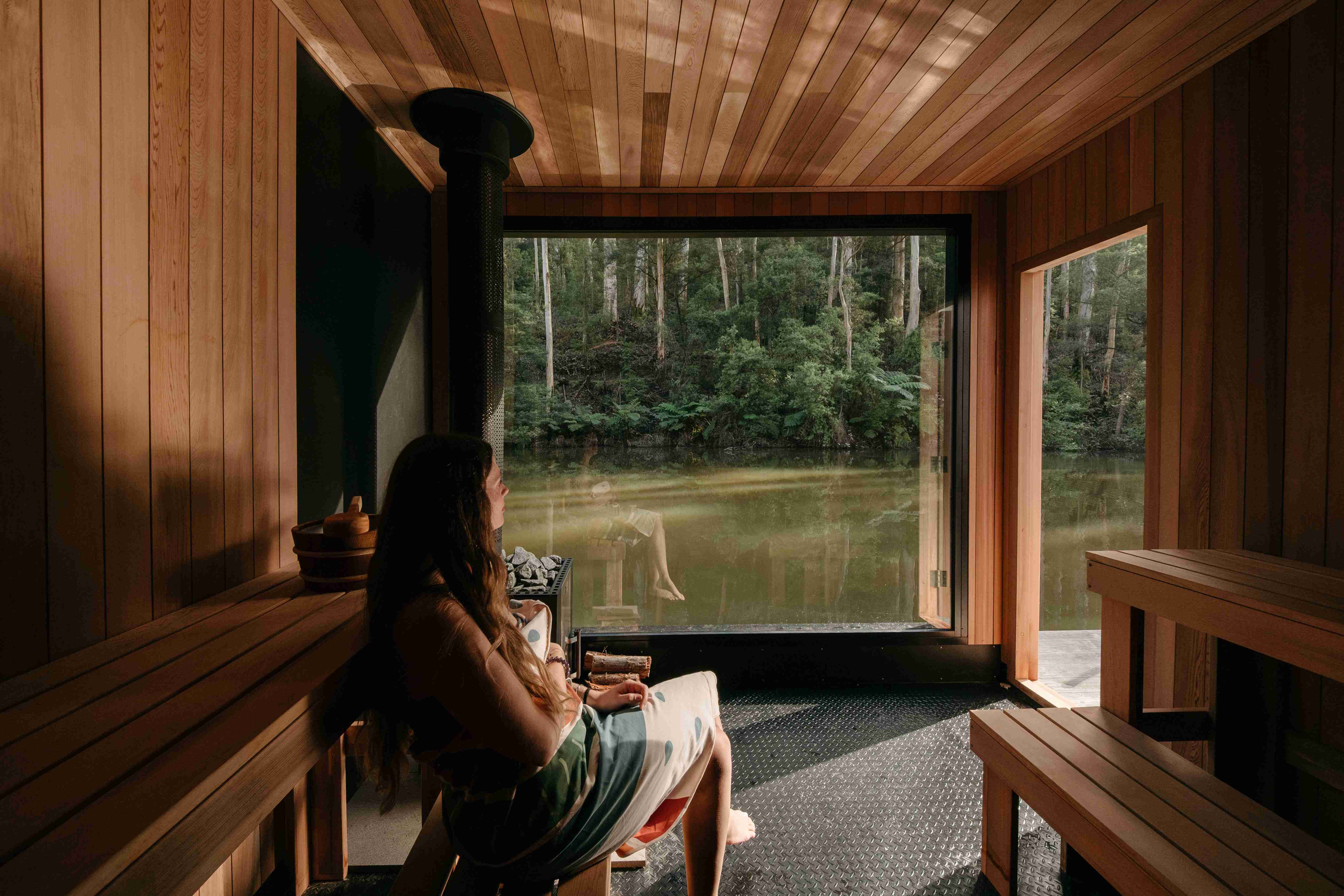 People relaxing by the floating saunas while others swim in the pool.