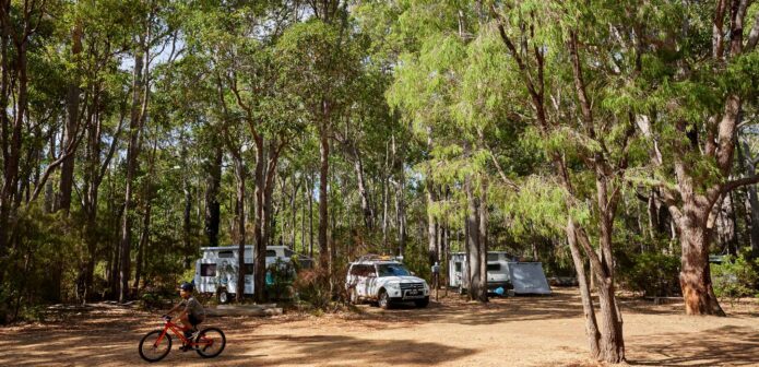 2 caravans parked in their RAC Margaret River Nature Park Sites with a person riding their bike.
