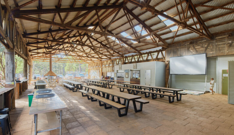 The Mill at RAC Margaret River Nature Park with a long communal table with bench seating and barbecue facilities.