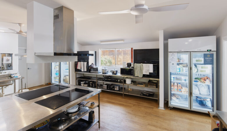 RAC Margaret River Nature Park kitchen equipped with induction hot plates, an industrial fridge, appliances, and utensils.