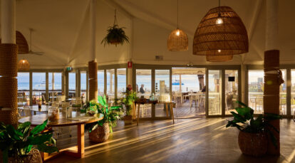 Restaurant with ocean view out the windows and golden hour lighting