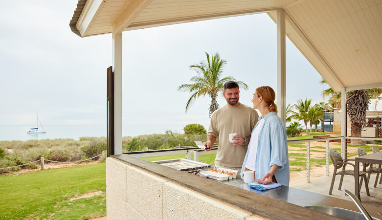 Couple cooking on barbeque overlooking the ocean