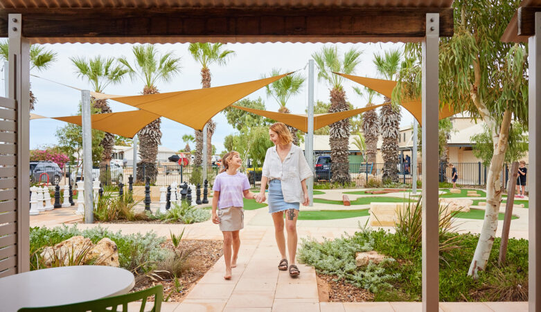 Parent and child holding hands, smiling, walking