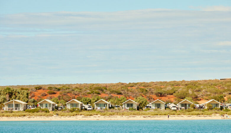 Villa lined beach with blue waters and skies