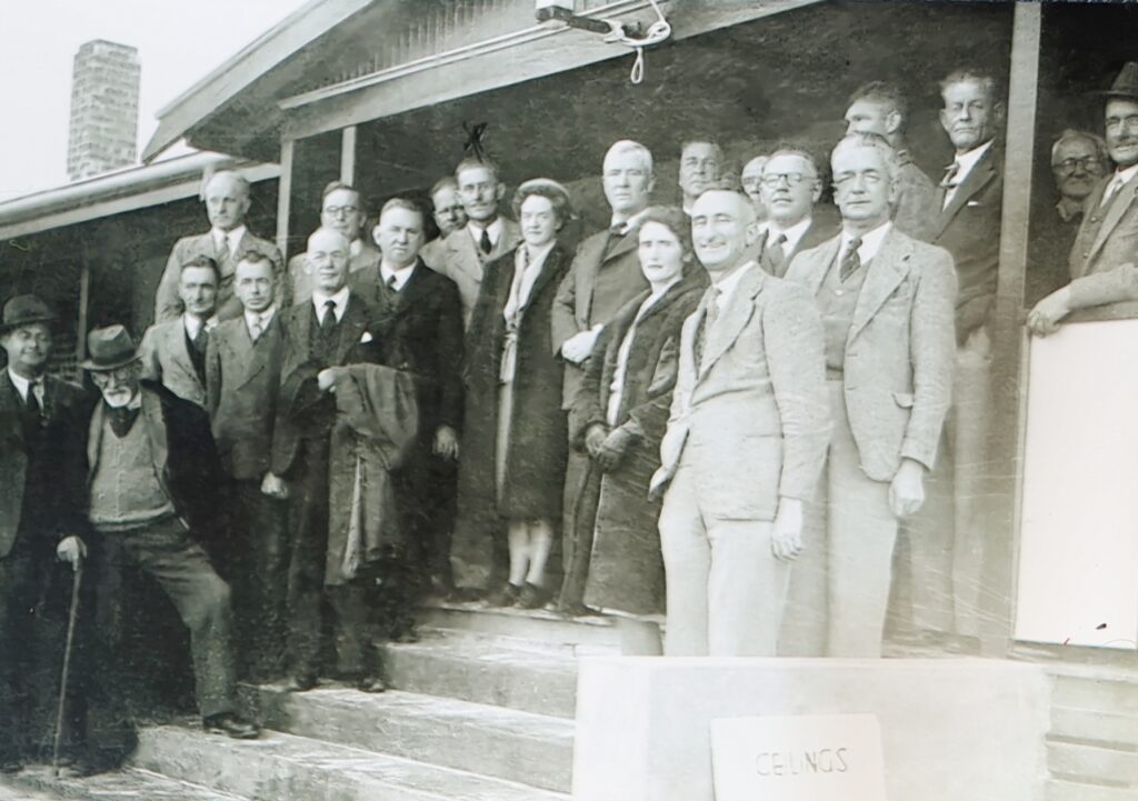 Black and white image of group people standing on the steps of the old fresh air league