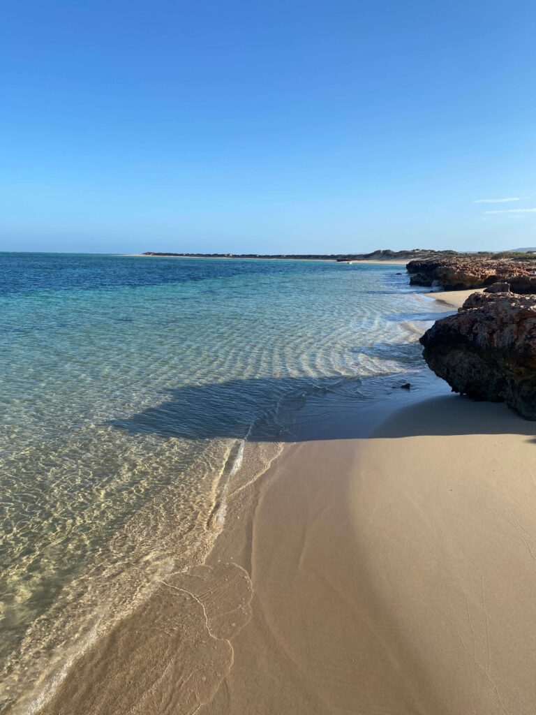 Image of clear blue waters at sunrise on beach