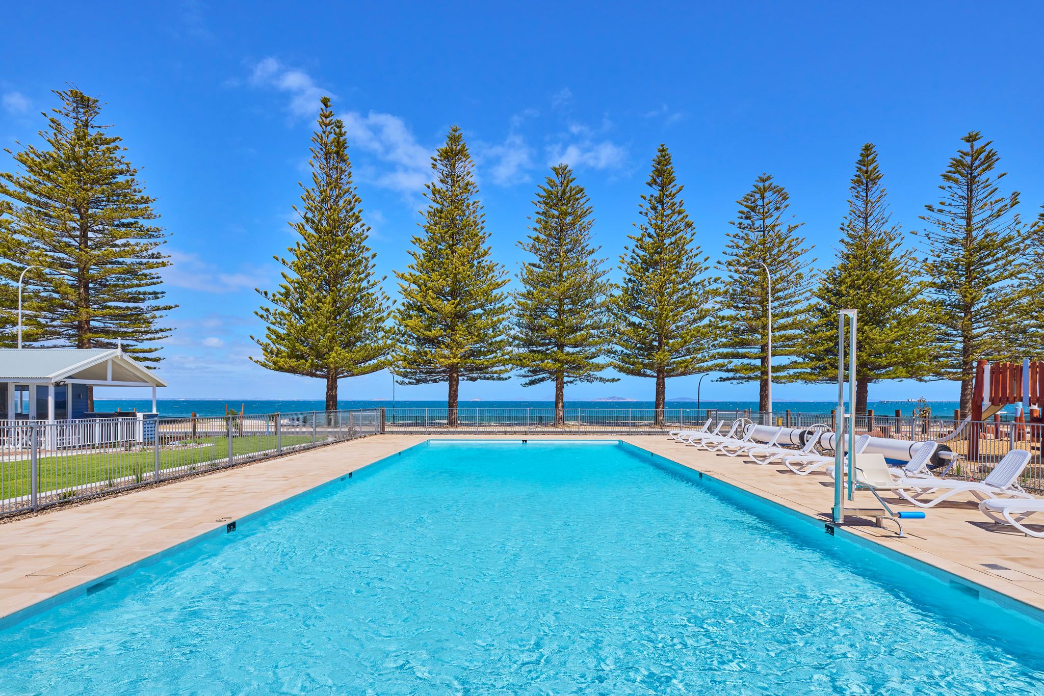 Our Esperance Holiday Park pool, overlooking Esperance Bay on a sunny day. This image features the accessible chair lift for our guests use.