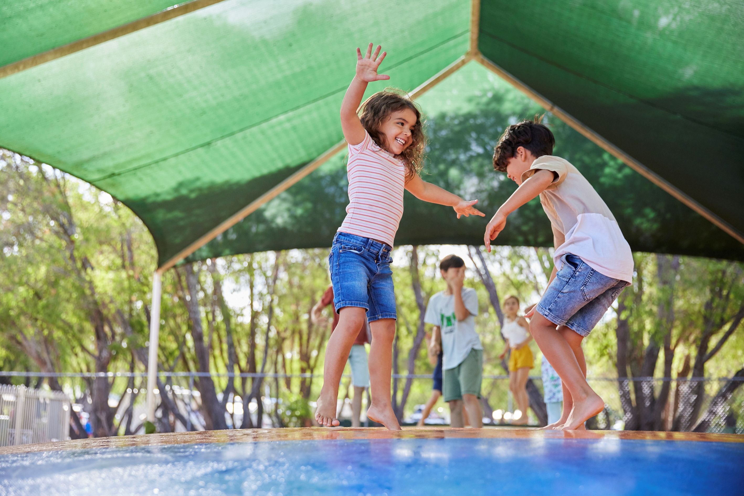 Siblings jumping on the RAC Busselton Holiday Park jumping pillow.
