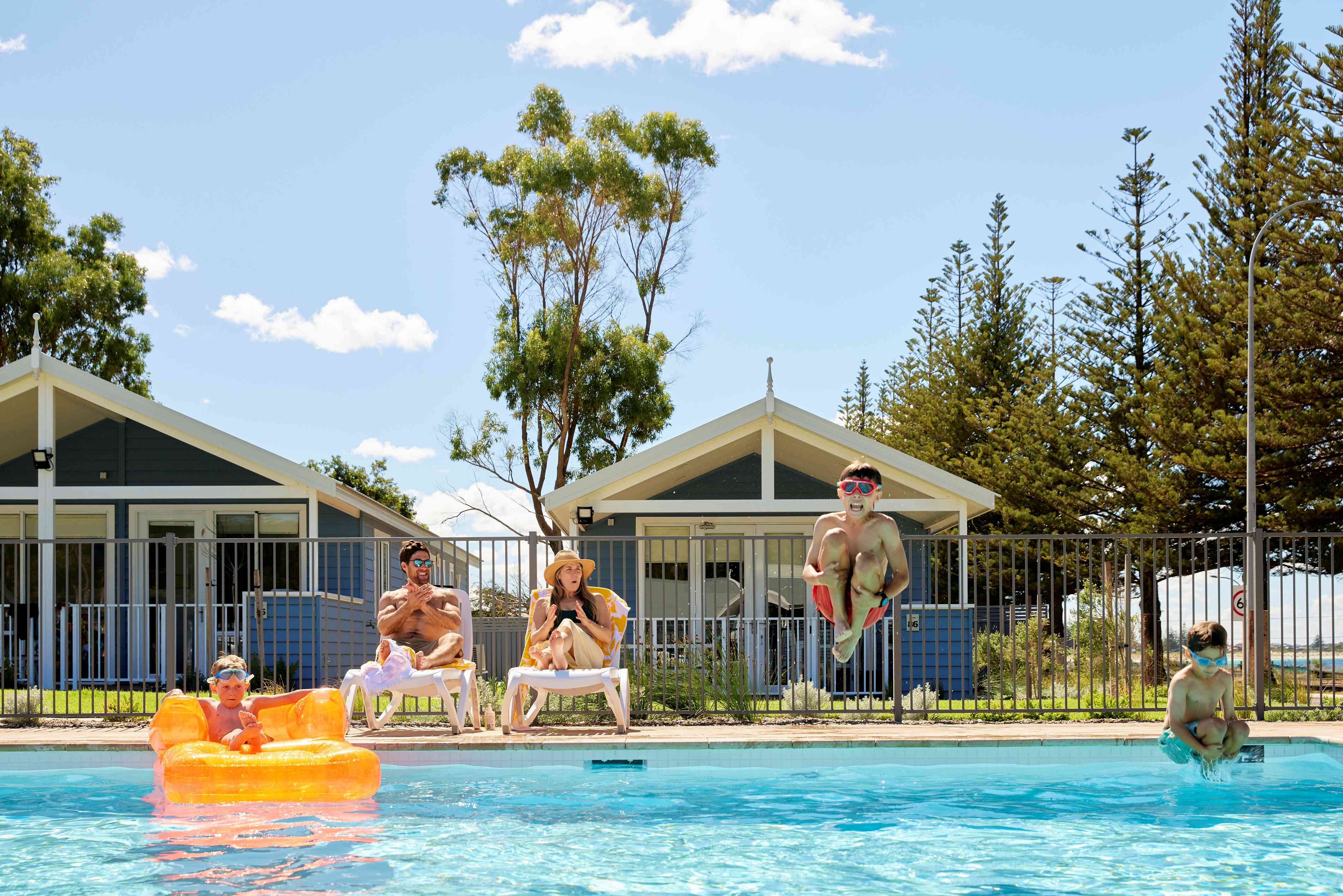 A family relaxing and swimming in the RAC Esperance Holiday Park pool.